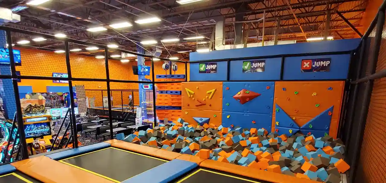 Trampoline area with foam pit and climbing wall at GAME LAB, designed for children's birthday parties and entertainment activities.
